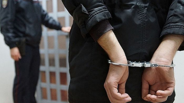На фотографии изображение рук в наручниках