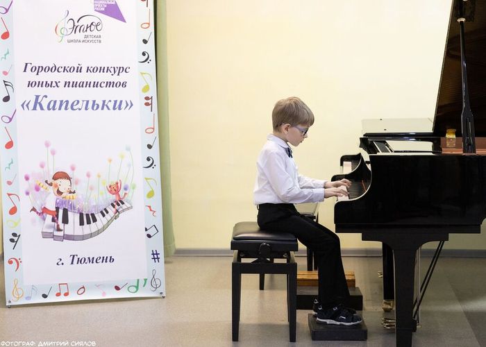 На фотографии выступление участника городского конкурса юных пианистов "Капельки"